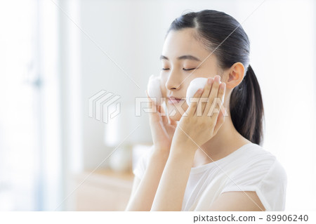 A young woman cleansing face A young woman cleansing face 89906240