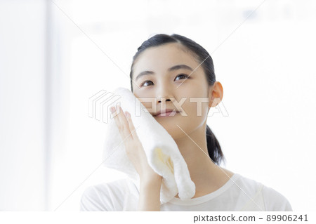 A young lady wiping his face with a towel A young lady wiping his face with a towel 89906241