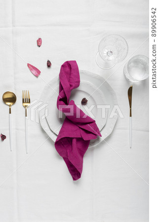 Fuchsia linen napkin on the white dish 89906542