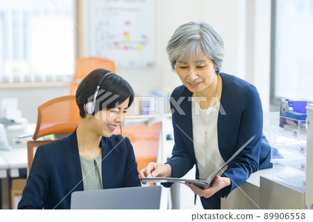 Senior generation boss and middle generation female operator meeting in the office 89906558