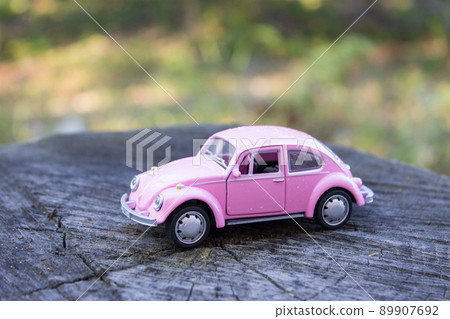 Toy pink car in drops of rain. Women's car concept Toy pink car in drops of rain. Women's car concept 89907692