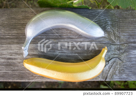 Golden and silver banana on a wooden background. Trendy concept, horizontal photo 89907723