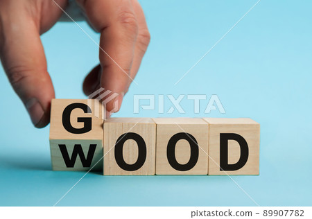 Word good to wood. Hand is turning a dice and changes the word good to wood. 89907782