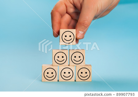 Rating customer experience. Hand putting wooden cube block shape with icon face smiley, The best 89907793