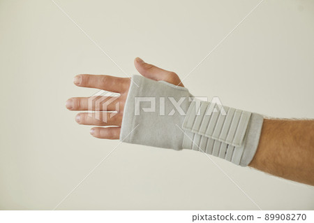 Man with tendonitis wears wrist brace that has compression and pain relief effect Man with tendonitis wears wrist brace that has compression and pain relief effect 89908270