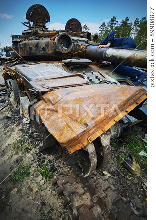Kyiv region, Ukraine - May 15, 2022: War in Ukraine. Highway Kyiv - Zhytomyr. People take selfies against destroyed russian tank after russian atack in Febrary. Kyiv region, Ukraine - May 15, 2022: War in Ukraine. Highway Kyiv - Zhytomyr. People take selfies against destroyed russian tank after russian atack in Febrary. 89908827