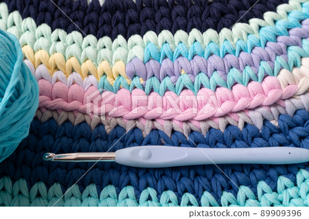 A rug made of knitted yarn and a crochet hook. Home needlework. A rug made of knitted yarn and a crochet hook. Home needlework. 89909396