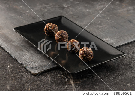 Still life of delicious, healthy chocolate balls with oat and dates on a rustic environment Still life of delicious, healthy chocolate balls with oat and dates on a rustic environment 89909501