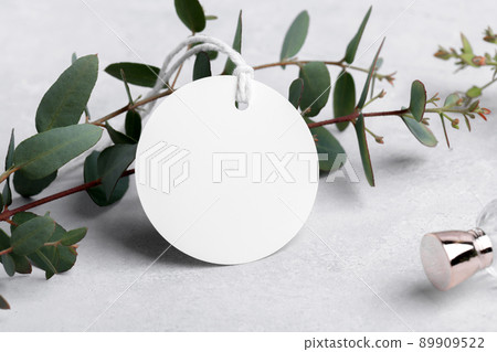 Round white gift tag mockup with eucalyptus leaves on grey background, label tag mockup, Wedding favor tag 89909522