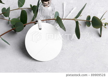 Round white gift tag mockup with eucalyptus leaves on grey background, label tag mockup, Wedding favor tag 89909528