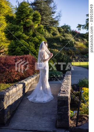 White Caucasian Adult Woman in a Wedding Dress standing outside in nature. 89910049