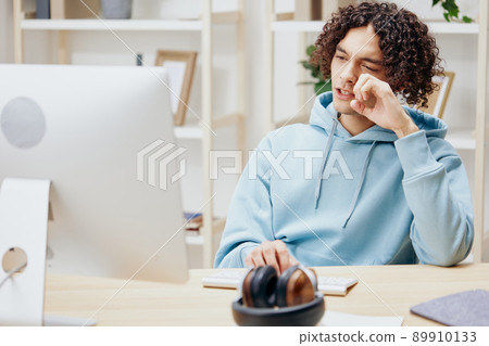 portrait of a man sitting at a table in front of a computer freelance Lifestyle 89910133