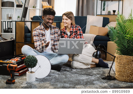 Multiracial family using laptop for renovation of new flat Multiracial family using laptop for renovation of new flat 89910989