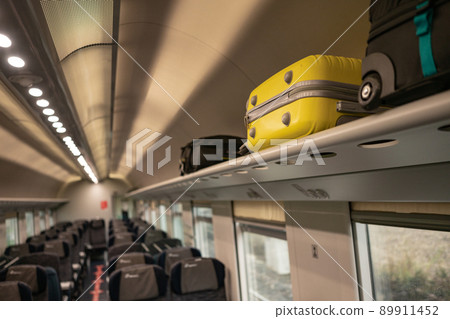Suitcases lying in the cabin of the train in places for the handle luggage. Travelling in Europe by train, euro-trek, luggage rack 89911452