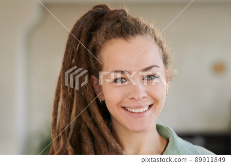 Portrait of smiling attractive girl with dreads in ponytail posing in modern office 89911849