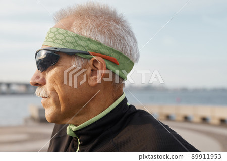 Close up horizontal side view portrait shot of Caucasian aged man wearing sporty sunglasses running Close up horizontal side view portrait shot of Caucasian aged man wearing sporty sunglasses running 89911953
