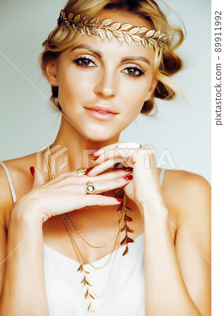 young blond woman dressed like ancient greek godess, gold jewelry close up isolated, summer trends 89911992