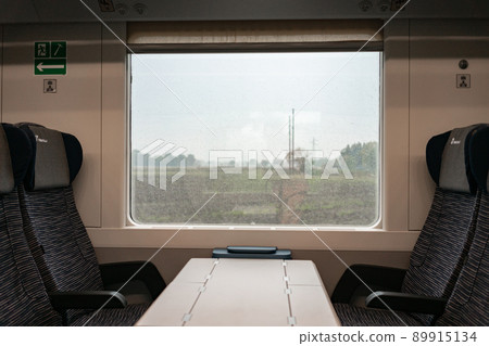 4.10.2021 Milan, Italy - The window of the European train and the empty passenger seats of the Trenitalia train 89915134