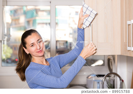 Woman cleaning kitchen with rag 89915788