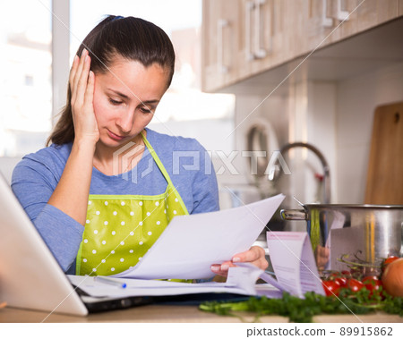 Tired young woman reading recipe in the kitchen 89915862