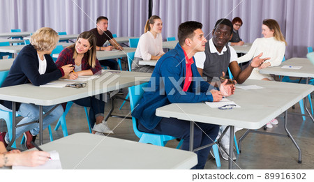 Adult students discussing lesson 89916302