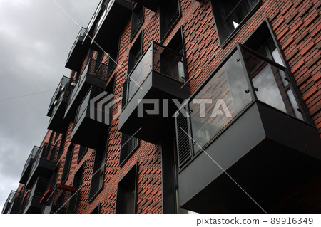 Exterior of a high-rise apartment building facade, windows and balconies. 89916349
