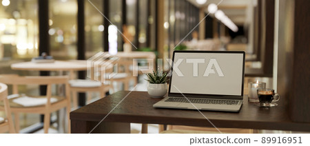 Modern comfortable coffee shop seating area interior with laptop on wooden table. 89916951