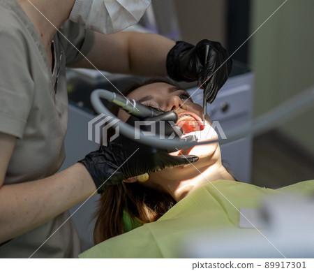 The process of removing braces.Beautiful woman in dental chair during procedure of installing braces to upper and lower teeth. Dentist and assistant working together, dental tools in their hands. The process of removing braces.Beautiful woman in dental chair during procedure of installing braces to upper and lower teeth. Dentist and assistant working together, dental tools in their hands. 89917301