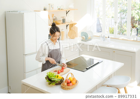 A woman standing in the kitchen A woman standing in the kitchen 89917331