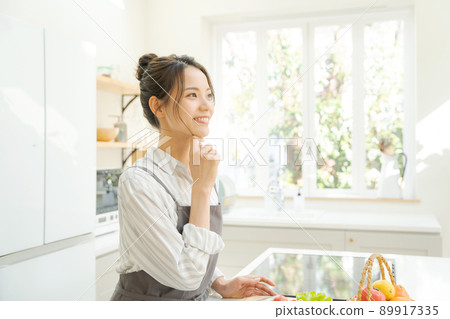 A woman standing in the kitchen A woman standing in the kitchen 89917335