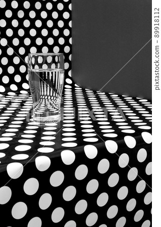 Abstract still life with a glass of liquid on a black and white background Abstract still life with a glass of liquid on a black and white background 89918112