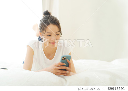 Women in their 20s looking at smartphones Women in their 20s looking at smartphones 89918591