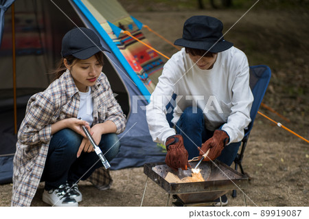 A couple wearing a bonfire with a fire starter 89919087