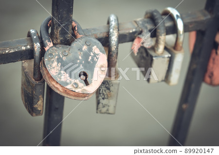Locks of love on the railing in the city park. Many locks of love hang on a metal fence in a city park Locks of love on the railing in the city park. Many locks of love hang on a metal fence in a city park 89920147