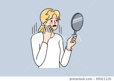 Unhappy woman look in mirror worrying about acne  89921126