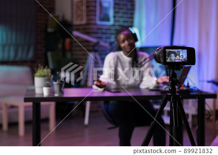 Online influencer creating fun podcast content with videoblog, recording live discussion to broadcast on social media channel. Happy lifestyle blogger using vlogging equipment. 89921832