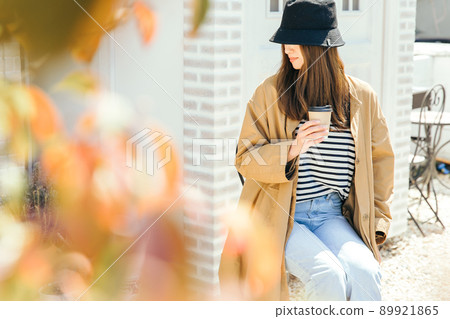 A woman drinking a hot drink at a cafe café A woman drinking a hot drink at a cafe café 89921865