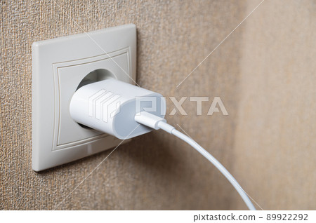 charger in the socket on the wall, close-up 89922292