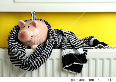 Concept of heating season with piggy bank on radiator 89922518