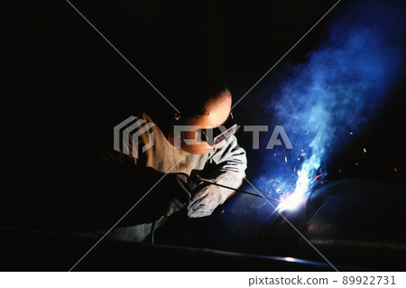 Skilled steel technician welding steel with safety equipment at hazardous construction industry site 89922731