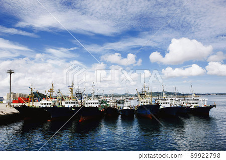 Fishing boats in the blue sea harbor with clear blue sky and clouds Fishing boats in the blue sea harbor with clear blue sky and clouds 89922798