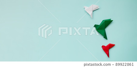 three paper origami pigeons red, white, green on light background 89922861
