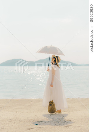 A woman with a parasol in a dress and a beautiful summer sky A woman with a parasol in a dress and a beautiful summer sky 89923920