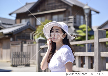 A young woman in a white hat and dress posing in the streets of Little Edo Sawara A young woman in a white hat and dress posing in the streets of Little Edo Sawara 89924155