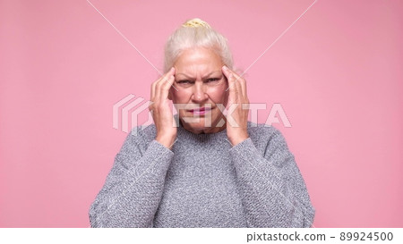 Senior woman suffering from headache being desperate and stressed 89924500