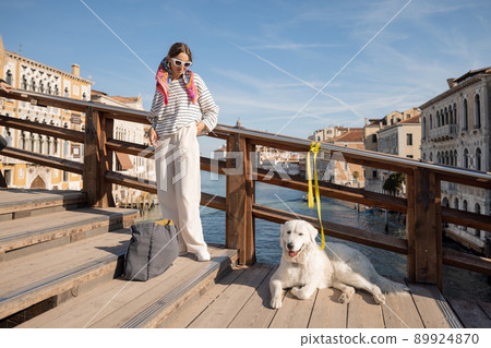 Woman with dog on the bridge in Venice Woman with dog on the bridge in Venice 89924870