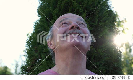 elderly man in a summer park dreaming looking around on summer day elderly man in a summer park dreaming looking around on summer day 89924908