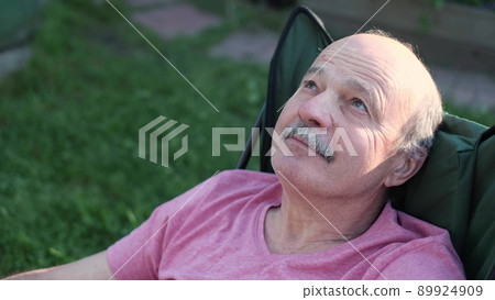Senior caucasian man smiling sitting in armchair 89924909