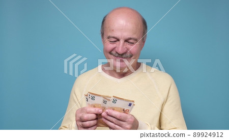Male pensioner counting money isolated on white background 89924912
