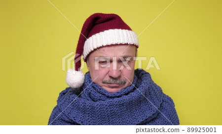 Displeased senior man in Santa Claus cap. 89925001